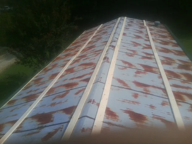 Rusted metal roof panels with new wood purlins before replacement — Storm Damage Roof Repair in Elyria by Roofing Brothers
