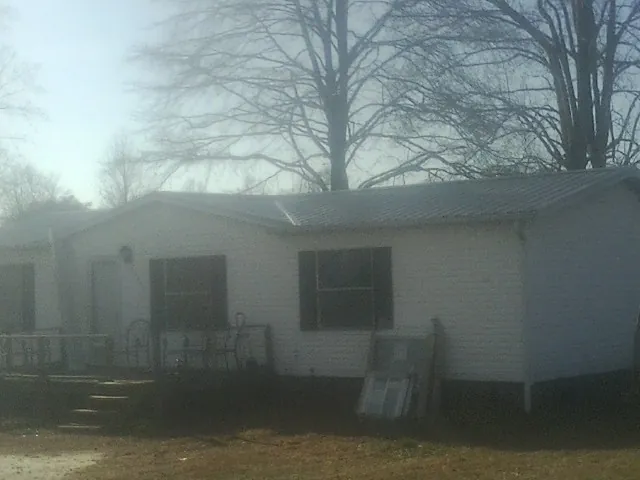 New metal roof on a white painted brick home on a foggy morning in Elyria