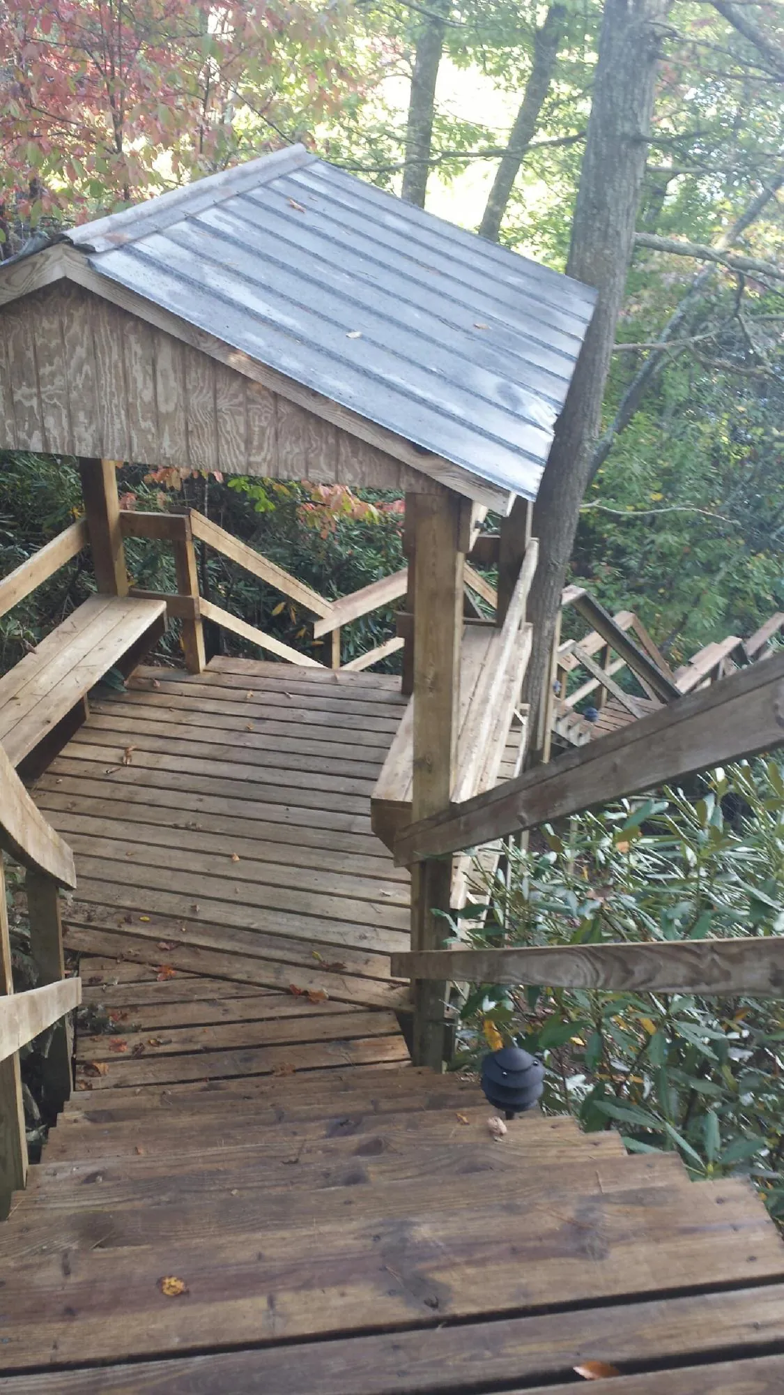 Metal roofed shelter over wooden steps on a wooded walkway — Skylight Repair & Installation work by our crew in Elyria